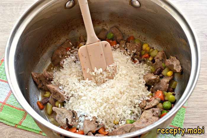 Минут через 6-7 дополняем ингредиенты в кастрюле рисом