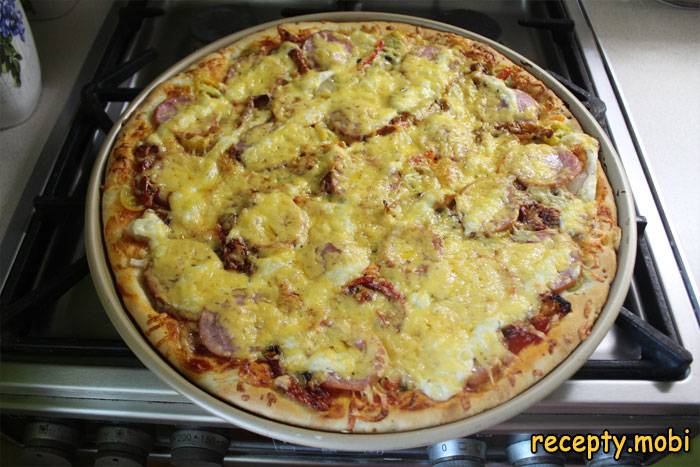 Pizza with cheese, ham, mushrooms and cherry tomatoes