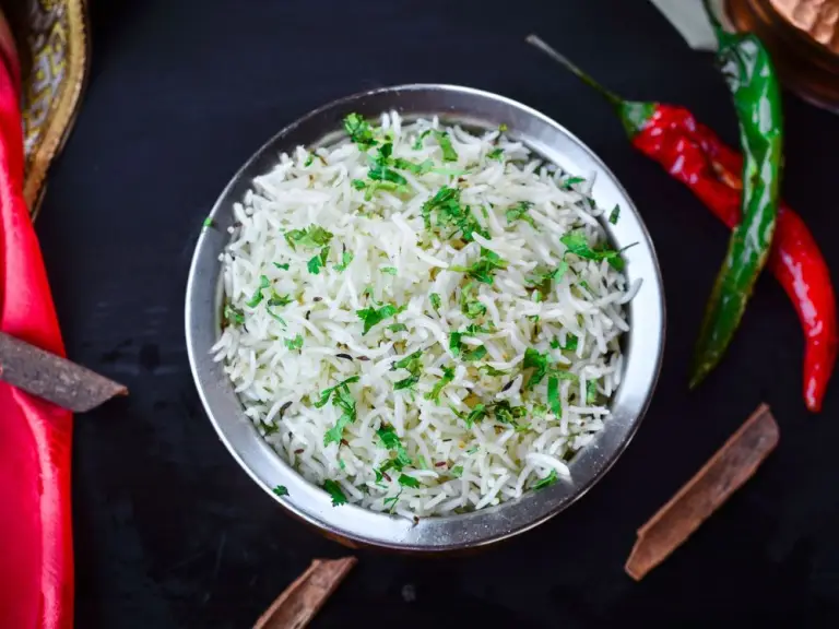 Fluffy basmati rice with herbs in a metal bowl